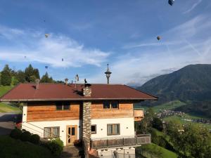 un bâtiment avec des cerfs-volants volant dans le ciel dans l'établissement Apartment Oberguggenhausen, à Brixen im Thale