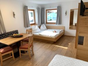 Cette petite chambre comprend un lit et une table. dans l'établissement Apartment Oberguggenhausen, à Brixen im Thale
