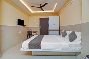 a bedroom with a bed and a ceiling fan at Super Townhouse 1266 Empire Executive in Pune