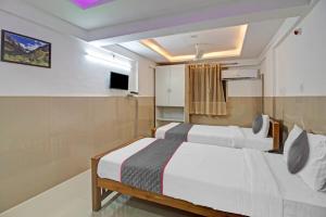 Habitación de hotel con 2 camas y TV en Super Townhouse 1266 Empire Executive, en Pune