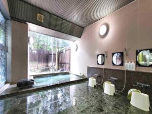 a large bathroom with a swimming pool and a large window at Guestroom Garden Azumino in Azumino