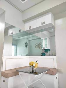 a table with a vase of flowers on it in a kitchen at Best Condo Studio within Limketkai Center in Cagayan de Oro