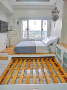 a bedroom with a bed with a wooden floor at Best Condo Studio within Limketkai Center in Cagayan de Oro