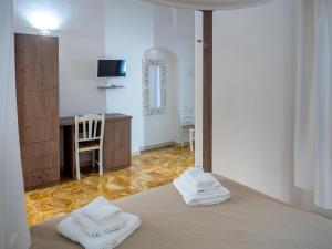 a bedroom with a bed with two white towels on it at Lucente Rooms & Suites in Ugento