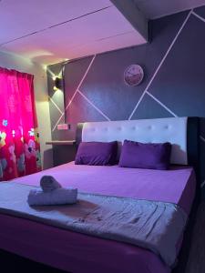 ein Schlafzimmer mit einem großen Bett mit lila Kissen in der Unterkunft JL Homestay Taman Pertama Satu in Lahad Datu