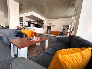ein Wohnzimmer mit Sofas und einem Tisch sowie eine Küche in der Unterkunft Hotel Pelikán in Lučenec