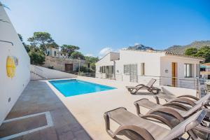 a villa with a swimming pool and lounge chairs at Can Botana Casa 8 - By Dream Villas Pollensa in Cala de Sant Vicenc +23 photos