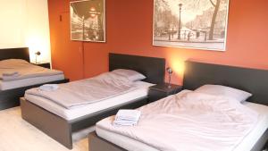 2 camas en una habitación con paredes de color naranja en Bett + Fitness en Kassel