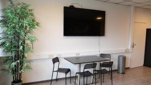 una mesa negra y sillas con TV en la pared en Bett + Fitness en Kassel