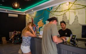 a man and a woman standing at a bar at Mad Monkey Hostel Siem Reap in Siem Reap