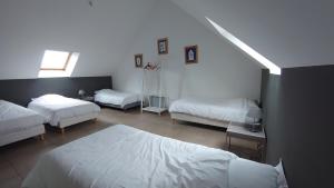 een slaapkamer met 3 bedden en een raam bij Les Chambres du Meunier in Juigné-sur-Loire