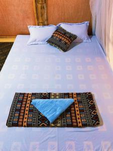 a bed with two pillows and a blue pillow on it at Lakeview Homestay Vu Linh in Yên Bình