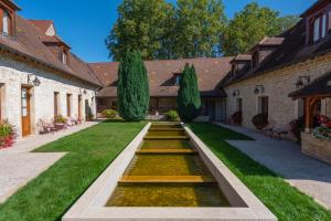 a garden with a pond in the middle of a yard at Hotel Le Clos De La Vouge in Vougeot