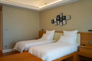 two beds sitting next to each other in a room at Residence G Nanshan in Shenzhen