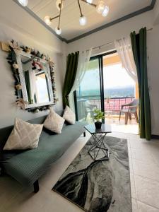 - un salon avec un canapé vert et une table dans l'établissement A Perfect Stay to Escape the City, à Baguio
