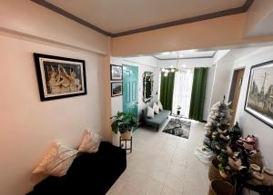 a living room with a couch and a christmas tree at A Perfect Stay to Escape the City in Baguio