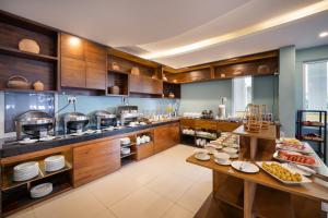 a large kitchen with wooden cabinets and food on tables at TRIPLE Riverside Villa Hotel HoiAn in Hoi An
