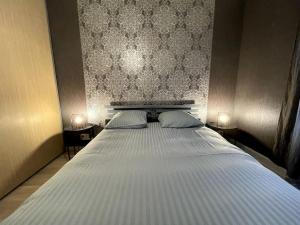 Un dormitorio con una cama grande con dos mesitas de noche. en Le Cocon Savoyard, en Albertville