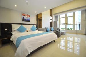ein großes Schlafzimmer mit einem großen Bett mit blauen Kissen in der Unterkunft WAIFIDEN Duplex Hotel Apartment Zhongyong Jinyu Branch in Guangzhou