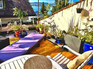 a balcony with a purple table and chairs and plants at Zurich at the Lake double room in historic house shared Bath in Kilchberg +11 photos
