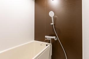 eine Dusche im Bad mit Duschkopf in der Unterkunft HJ PLACE SHIBUYA in Tokio