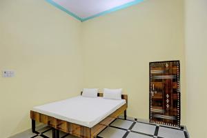 OYO J.M.D Restaurant &rooms في Jhājhar: غرفة نوم بسرير في غرفة