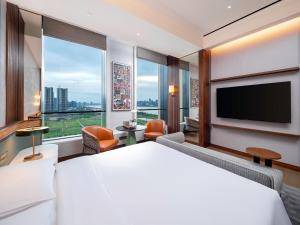 Habitación de hotel con cama grande y TV de pantalla plana. en MUMIAN Hangzhou en Hangzhou