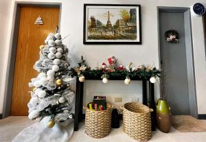 a christmas fireplace with a christmas tree and baskets at A Perfect Stay to Escape the City in Baguio
