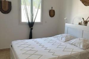 een wit bed in een slaapkamer met een raam bij "Villa Les Didi" Jacuzzi, proche de la mer in Solaro