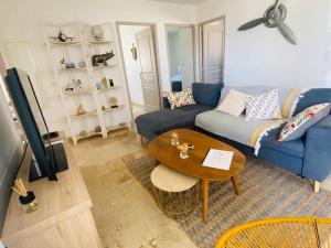 een woonkamer met een blauwe bank en een tafel bij "Villa Les Didi" Jacuzzi, proche de la mer in Solaro