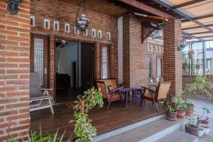 Klaten的住宿－RedDoorz Syariah near Stasiun Klaten，砖砌建筑中带桌椅的庭院