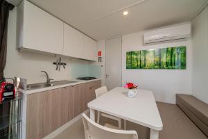 a small kitchen with a white table and chairs at Camping&Village Le Cernie in Lotzorai
