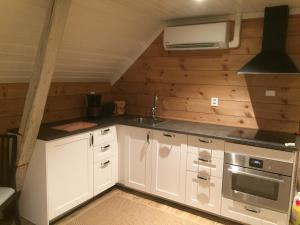 a kitchen with white cabinets and a stove at Old town boutiqe apartments/ Gamle Lærdalsøyri boutique leiligheter in Lærdalsøyri