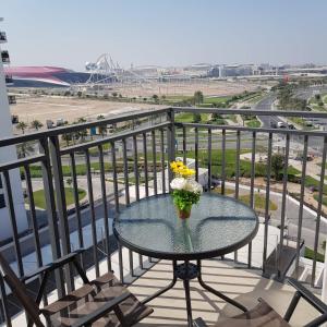 een tafel met een vaas met bloemen op een balkon bij B8 Studio close to Formula 1 with Ferrari world view in Abu Dhabi