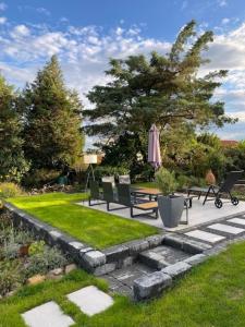 a garden with benches and an umbrella and grass at Ferienhaus - b42936 in Schotten