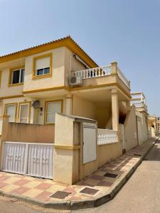 a house with a fence in front of it at Playa Flamenca 2 bed Apt Sol De Mar in Villamartin