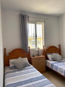 a bedroom with two beds and a window at Playa Flamenca 2 bed Apt Sol De Mar in Villamartin