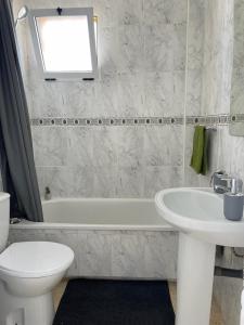 a bathroom with a sink and a tub and a toilet at Playa Flamenca 2 bed Apt Sol De Mar in Villamartin