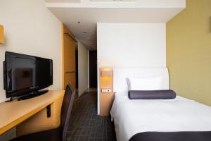 a hotel room with a bed and a flat screen tv at Tokyu Stay Kamata - Tokyo Haneda in Tokyo