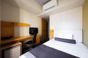 a hotel room with a bed and a desk and a tv at Tokyu Stay Kamata - Tokyo Haneda in Tokyo