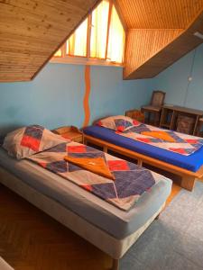 two twin beds in a room with a window at Arany Apartman in Cegléd