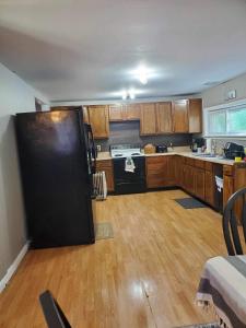 a kitchen with a black refrigerator and wooden cabinets at Jeans Place in Northfork