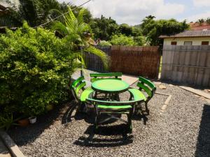 a patio with a green table and chairs at Lemon Guesthouse in Ko Chang