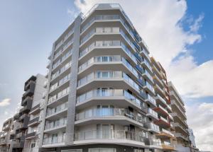 an apartment building with balconies and a blue sky at Hotel Mistral St Julian's, Affiliated by Meliá in St Julian's