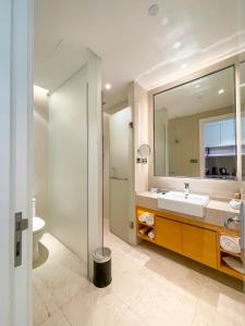 La salle de bains est pourvue d'un lavabo et d'un miroir. dans l'établissement Residence G Nanshan, à Shenzhen