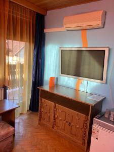 salon z telewizorem z płaskim ekranem na ścianie w obiekcie Arany Apartman w mieście Cegléd