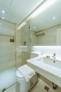 uma casa de banho com um WC branco e um lavatório. em Sugarland Hotel em Bacolod