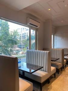 a waiting room with white chairs and a large window at J Hotel and Banquets in Mumbai