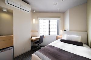 a hotel room with a bed and a desk and a window at Tokyu Stay Kamata - Tokyo Haneda in Tokyo