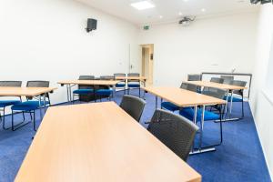 une salle de classe vide avec des tables et des chaises dans l'établissement Resort Vrchlabí, à Vrchlabí